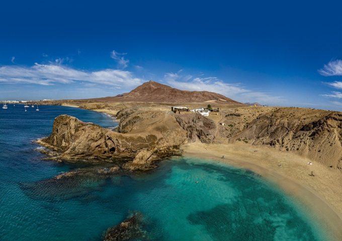 Playa de Papagayo Lanzarote — secluded golden sand cove with crystal-clear turquoise water and volcanic cliffs at the southern tip of the island
